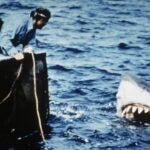 Actors Richard Dreyfuss (L) and Robert Shaw lean off the back of their boat, holding ropes as they watch the giant Great White shark emerge from the water in a still from the film, 'Jaws,' directed by Steven Spielberg. (Photo by Universal Pictures/Courtesy of Getty Images) Library Tag Magazine 07252010