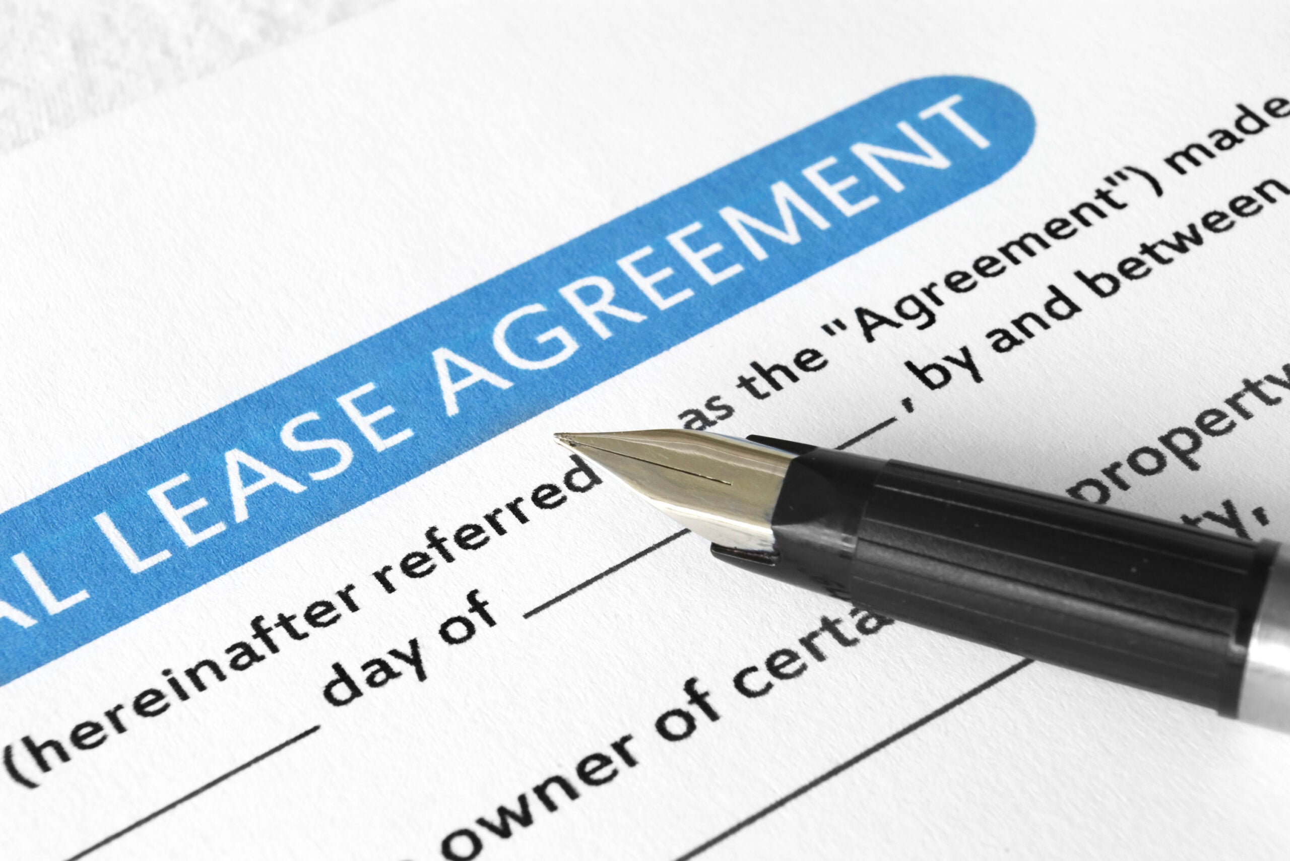 A black ballpoint sits on a lease agreement.