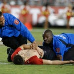 FILE - In this Sept. 12, 2016, file photo, a fan is tackled by security officers during the second half of an NFL football game between the San Francisco 49ers and the Los Angeles Rams in Santa Clara, Calif. Westwood One radio announcer Kevin Harlan's call of the fan's movements has become a trending topic online. (AP Photo/Tony Avelar, File)