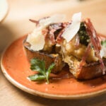 Soppressata and white bean bruschetta with grilled red onion fennel pollen and pecorino.