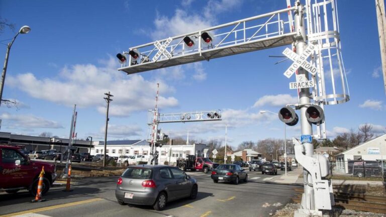 Vehicles crossed over rail tracks on Brighton Street in Belmont where a train had earlier struck a car on Friday.
