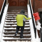 Snow is cleared from the steps of 421 Massachusetts Avenue.