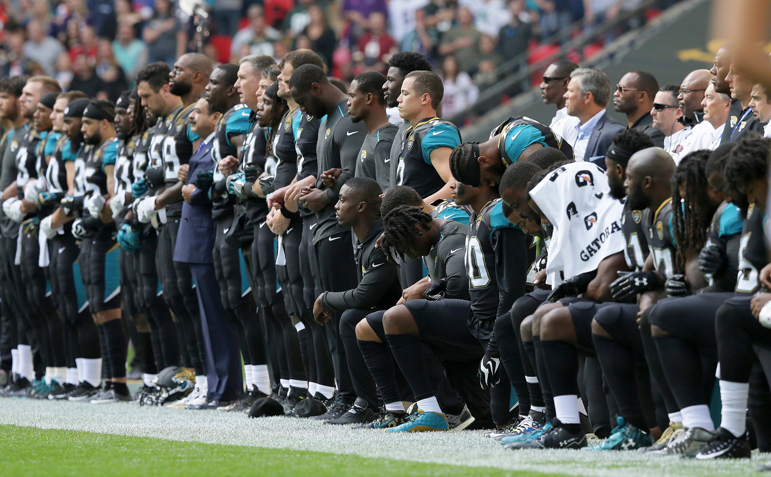 Owner Arthur Blank stands arm-in-arm with Falcons during anthem