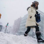 Pedestrians walk in snow