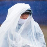 Runners make their way through the rain in the athletes's village prior to the start of the running of the Boston Marathon in Hopkinton.