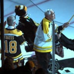Johnny Bucyk waves a Bruins flag with Peter Frates before Game 1 of the Bruins-Maple Leafs 2018 Stanley Cup Playoffs series.