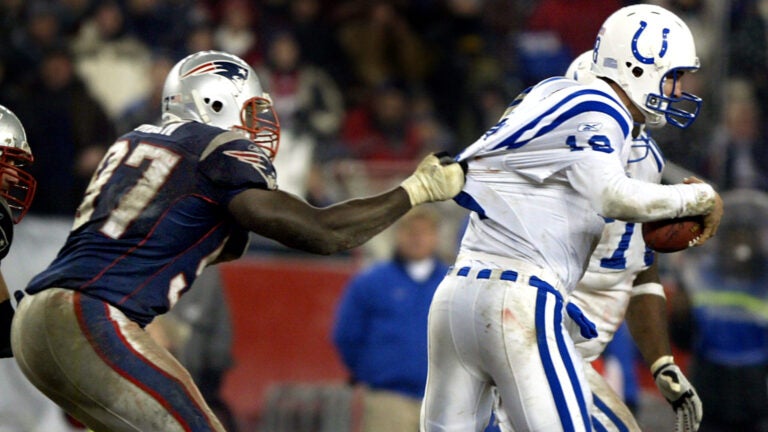 Patriots defensive lineman Jarvis Green (97,left), has Colts' quarterback Peyton Manning .