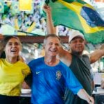 Brazil fans, from left, Minele Freitas, Gilbert Almeida and Wallace Freitas celebrate a goal while watching the World Cup soccer game against Costa Rica at a cafe in Framingham, Mass., Friday, June 22, 2018. Brazil defeated Costa Rica 2-0. (AP Photo/Michael Dwyer)
