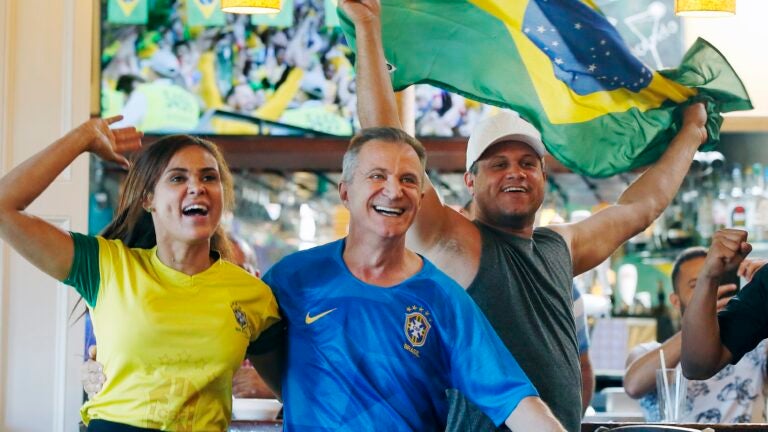 Brazil fans, from left, Minele Freitas, Gilbert Almeida and Wallace Freitas celebrate a goal while watching the World Cup soccer game against Costa Rica at a cafe in Framingham, Mass., Friday, June 22, 2018. Brazil defeated Costa Rica 2-0. (AP Photo/Michael Dwyer)