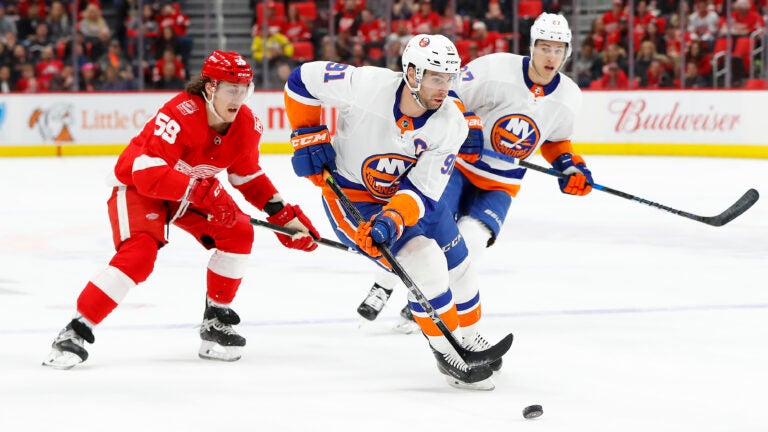 FILE - In this April 7, 2018, file photo, New York Islanders center John Tavares (91) carries the puck against the Detroit Red Wings during the first period of an NHL hockey game in Detroit. As the No. 1 pending free agent, Tavares not only gets to hand out his rose like hockey’s version of “The Bachelor” but can set the tone for the rest of the players available. He can only get an eight-year contract from the Islanders--unless they execute a sign-and-trade to recoup some value--and could very well become the league’s second-highest-paid player behind Edmonton Oilers captain Connor McDavid, who makes an average of $12.5 million a season. (AP Photo/Paul Sancya, File)
