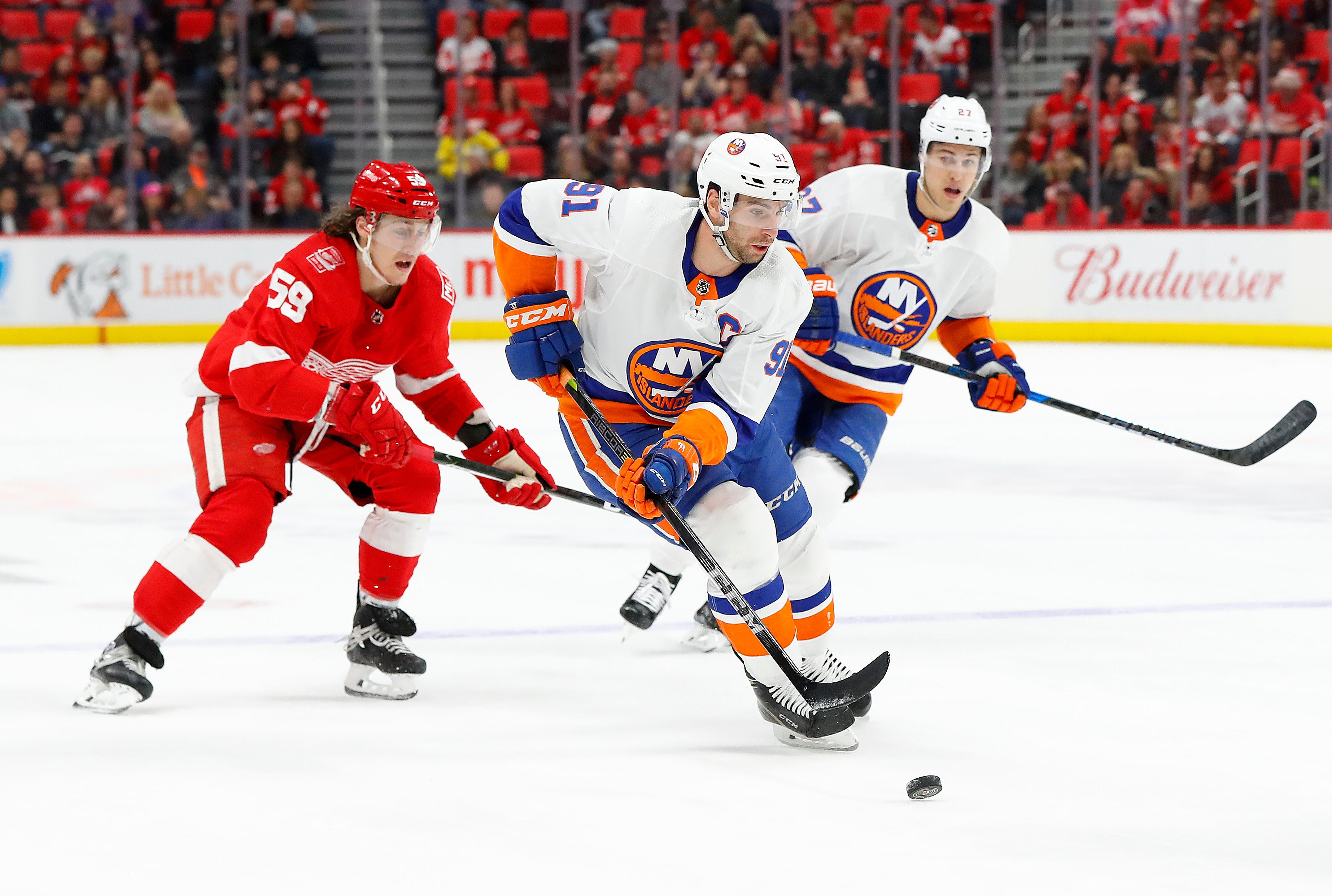 FILE - In this April 7, 2018, file photo, New York Islanders center John Tavares (91) carries the puck against the Detroit Red Wings during the first period of an NHL hockey game in Detroit. As the No. 1 pending free agent, Tavares not only gets to hand out his rose like hockey’s version of “The Bachelor” but can set the tone for the rest of the players available. He can only get an eight-year contract from the Islanders--unless they execute a sign-and-trade to recoup some value--and could very well become the league’s second-highest-paid player behind Edmonton Oilers captain Connor McDavid, who makes an average of $12.5 million a season. (AP Photo/Paul Sancya, File)