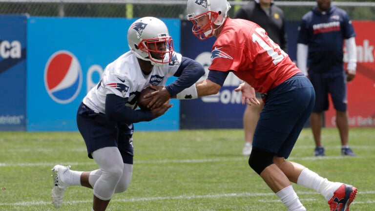 James White takes a handoff from Tom Brady during Patriots minicamp in June, 2018.