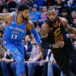 Cleveland Cavaliers forward LeBron James (23) drives past Oklahoma City Thunder forward Paul George (13) during the first half of an NBA basketball game in Oklahoma City, Tuesday, Feb. 13, 2018. (AP Photo/Sue Ogrocki)