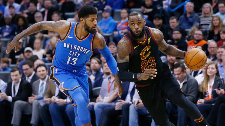 Cleveland Cavaliers forward LeBron James (23) drives past Oklahoma City Thunder forward Paul George (13) during the first half of an NBA basketball game in Oklahoma City, Tuesday, Feb. 13, 2018. (AP Photo/Sue Ogrocki)