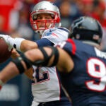 New England Patriots quarterback Tom Brady passes under pressure from Houston Texans J.J. Watt during the first quarter at Reliant Stadium in Houston, Texas December 1, 2013. (Jessica Rinaldi For The Boston Globe)