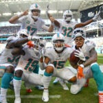 The Dolphins offense celebrates a fourth quarter touchdown against the Raiders.