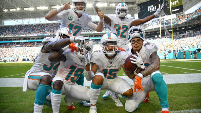 The Dolphins offense celebrates a fourth quarter touchdown against the Raiders.