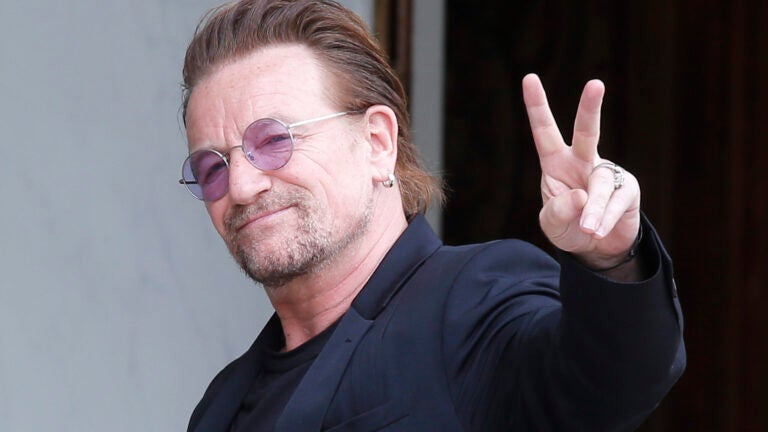 U2 singer Bono makes a peace sign as he arrives for a meeting in Paris.
