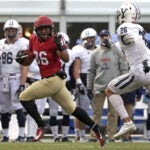 Harvard running back waves index finger at Yale defender.