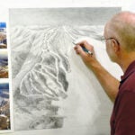 James Niehues works on a trail map for Gunstock, located in New Hampshire.