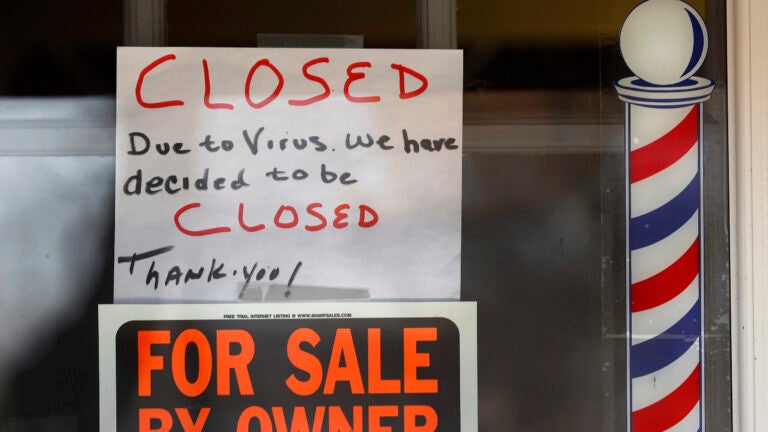 A hiring sign in the window of a shuttered 2nd Time Around