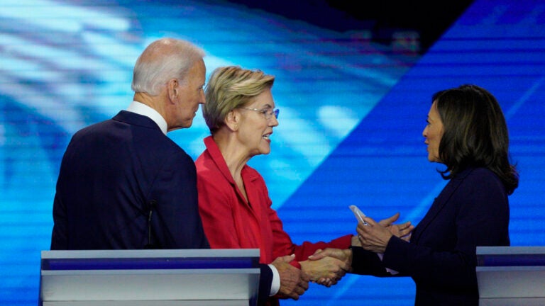 Joe Biden watches as then-candidates Sen. Elizabeth Warren, D-Mass., and Sen. Kamala Harris, D-Calif., shake hands after a Democratic presidential primary at Texas Southern University.