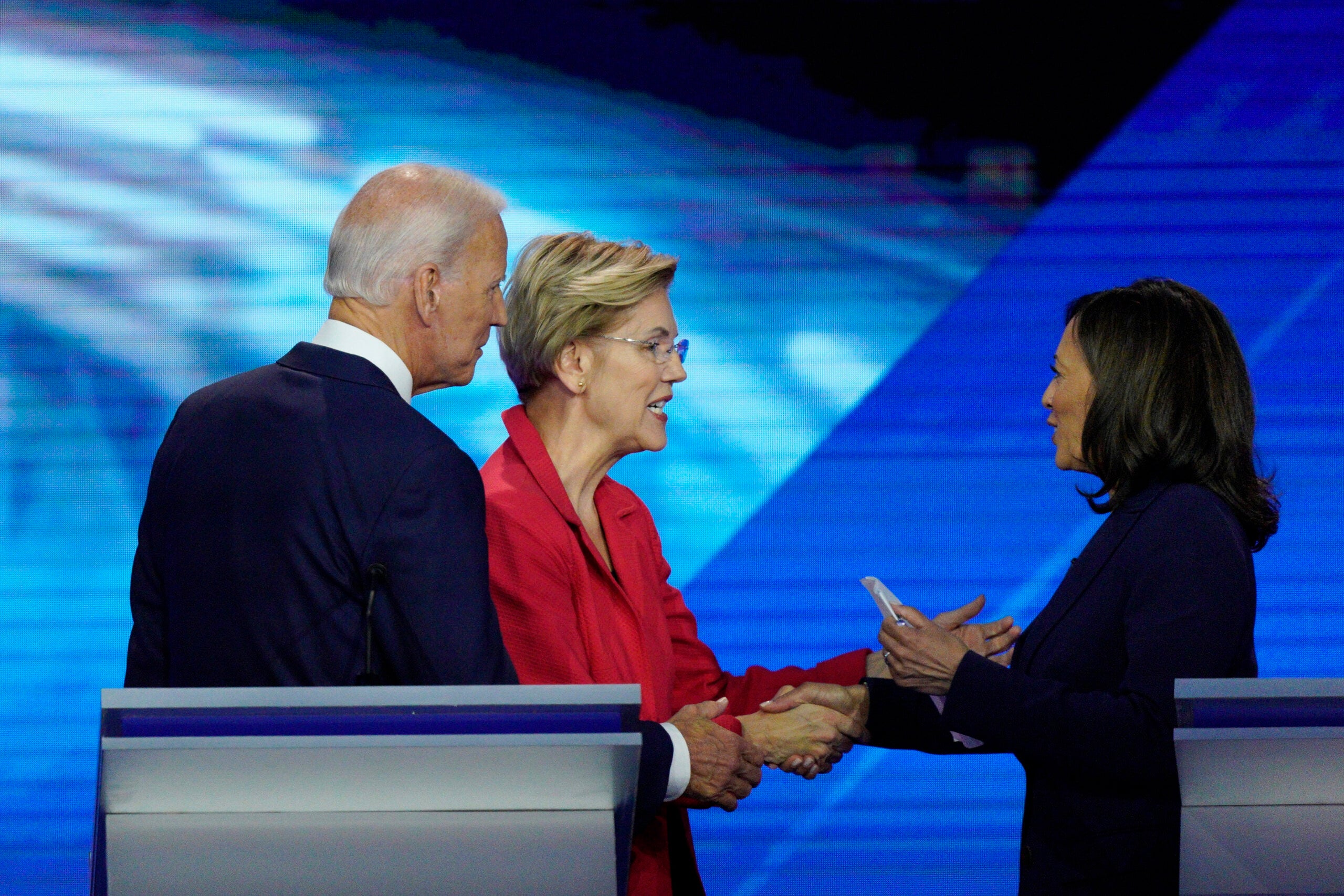 Joe Biden watches as then-candidates Sen. Elizabeth Warren, D-Mass., and Sen. Kamala Harris, D-Calif., shake hands after a Democratic presidential primary at Texas Southern University.