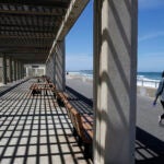 People walk along the Nantasket Beach boardwalk.