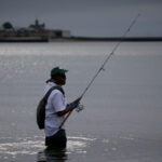 A man fishing off Carson Beach.