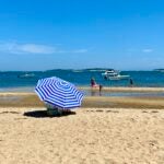 A woman shields herself from the sun at South Orleans Beach.