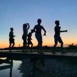 Boys on a boardwalk at sunset in Sandwich