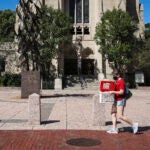 A woman carries crates through Boston University's campus.