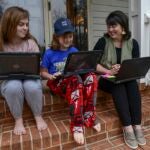 Students working on laptops in casual clothing.