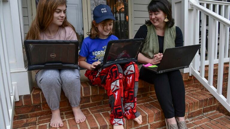 Students working on laptops in casual clothing.