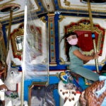 Children ride on The Boston Common Frog Pond Carousel.
