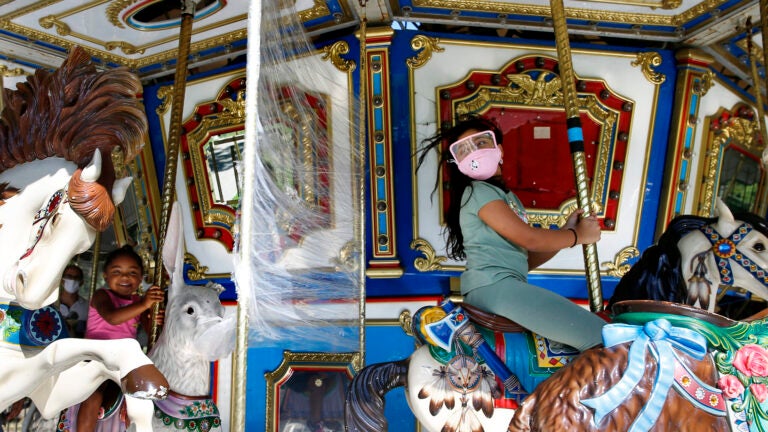 Children ride on The Boston Common Frog Pond Carousel.
