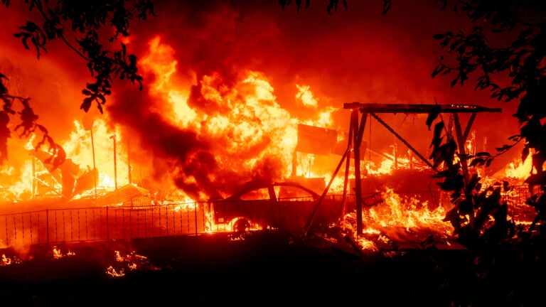 Flames consume a home and car.