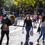 People cross the street in Somerville's Davis Square.