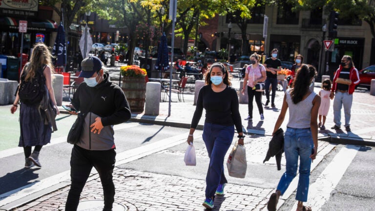 People cross the street in Somerville's Davis Square.