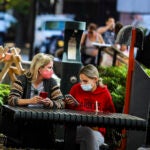Women sit outside in Davis Square.