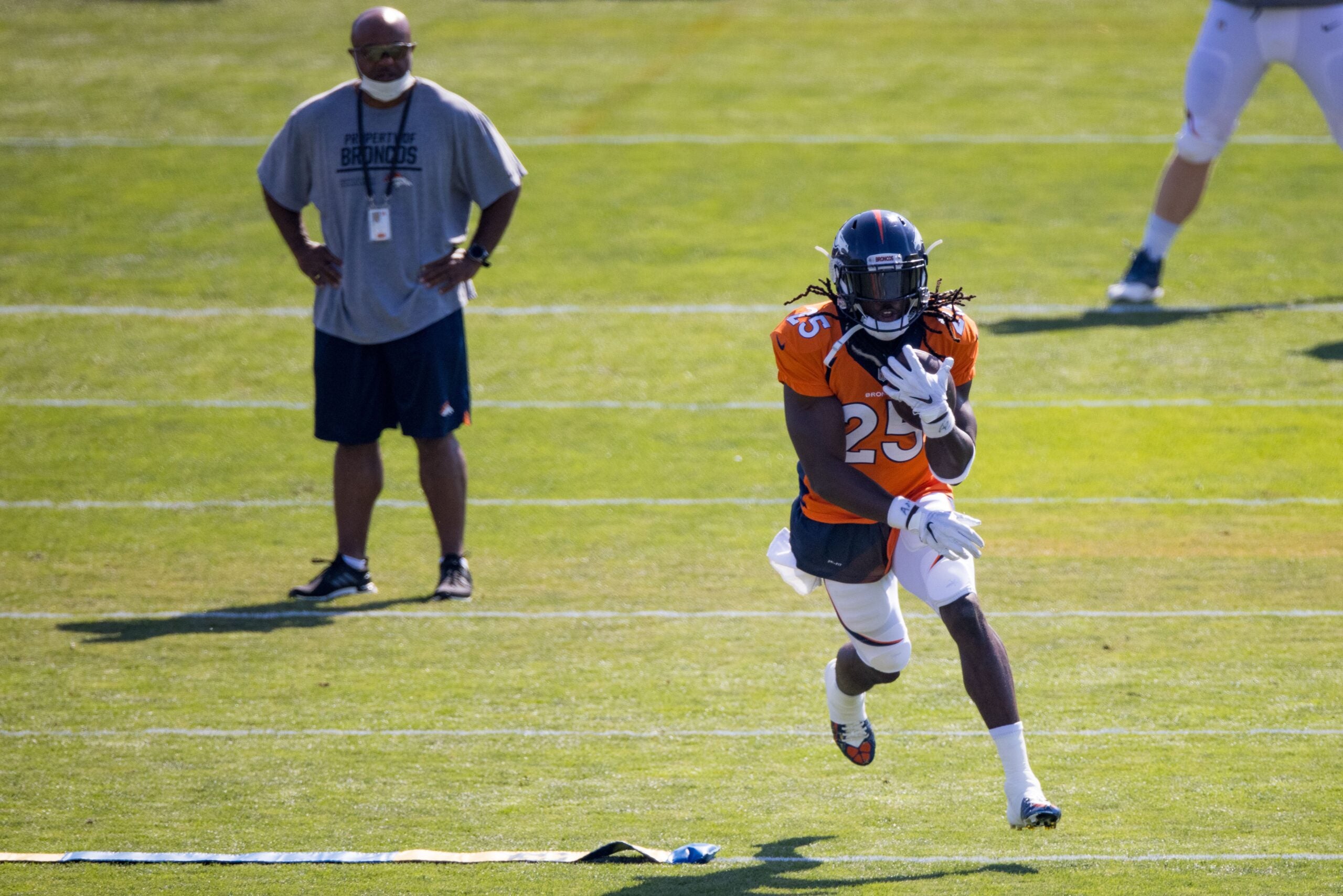 Denver Broncos running backs coach Curtis Modkins while taking