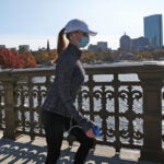 A woman walks across the Longfellow Bridge.