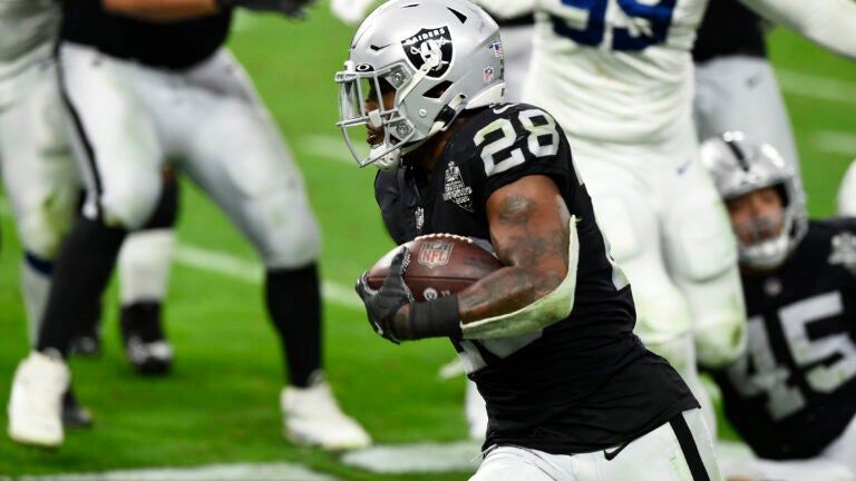 Oakland Raiders running back Josh Jacobs (28) warms up before an NFL  football game against the …