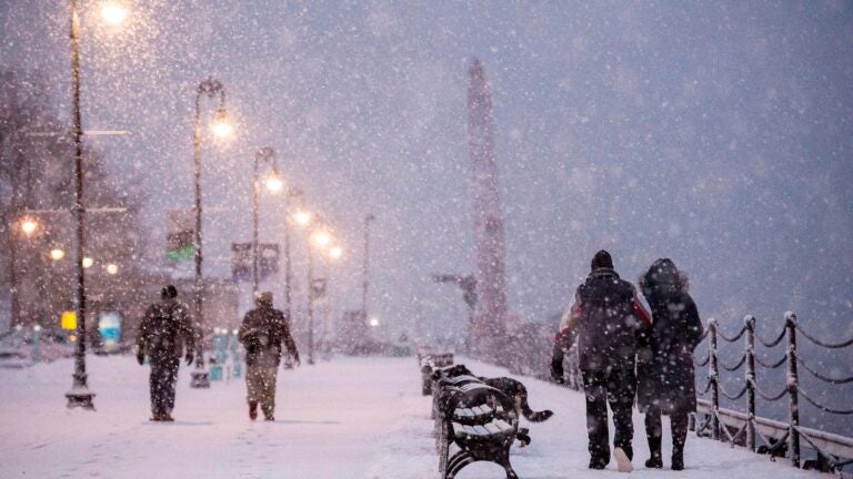 People walk through heavy snow fall in the Navy Yard during a winter storm.