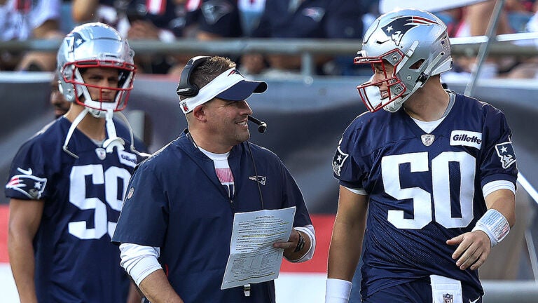 New England Patriots fans hold a signs welcoming back quarterback