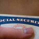 a picture of a thumb holding a Social Security card to illustrate retirement and retirees