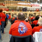 A man shown from behind wearing a T shirt depicting the Tewksbury Memorial High School Redmen mascot