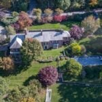 An aerial view shows the home, the surrounding yard and pool, and the street.