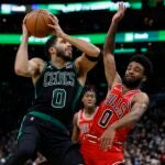 Boston Celtics' Jayson Tatum, left, shoots against Chicago Bulls' Coby White during the second half of an NBA basketball game, Saturday, Jan. 15, 2022, in Boston.
