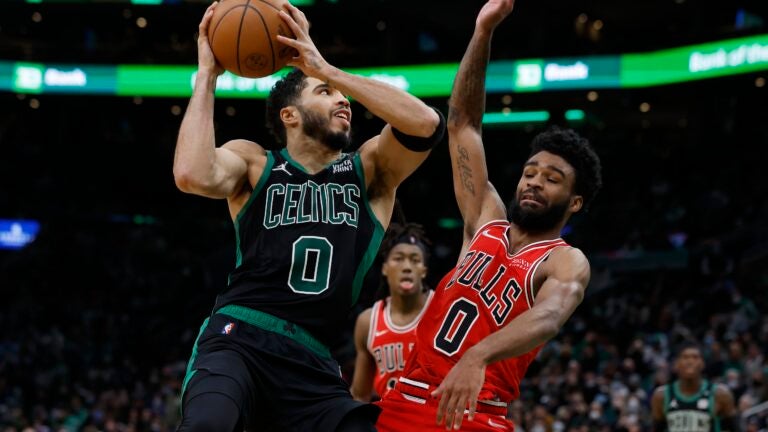 Boston Celtics' Jayson Tatum, left, shoots against Chicago Bulls' Coby White during the second half of an NBA basketball game, Saturday, Jan. 15, 2022, in Boston.